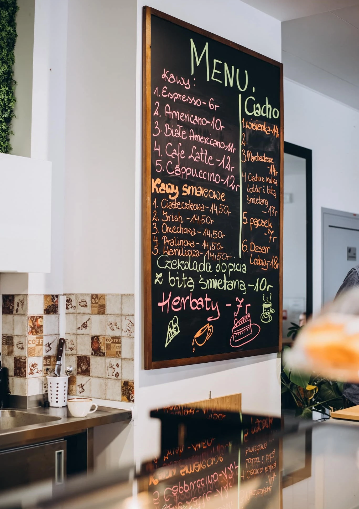 Ręcznie pisane kredą menu Kawiarni Harmonia z ofertą kaw specialty na czarnej tablicy